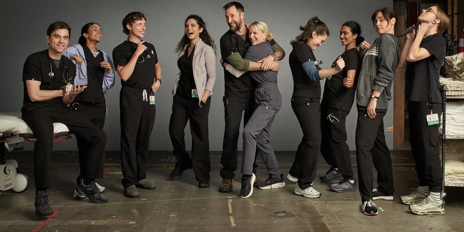 The cast of The Pitt in scrubs and hospital uniforms in a trauma bay